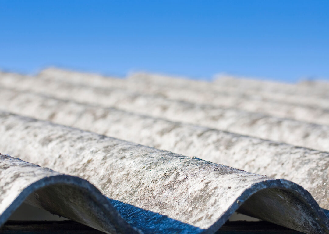 Old aged dangerous roof made of corrugated asbestos panels.