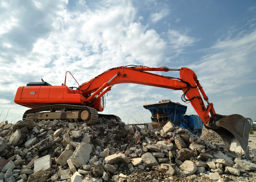 Demolition construction site activity. Lateral view of a big crawler.